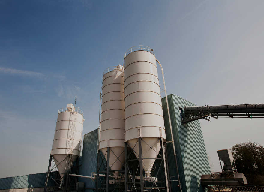 three silos next to corrugated iron warehouse